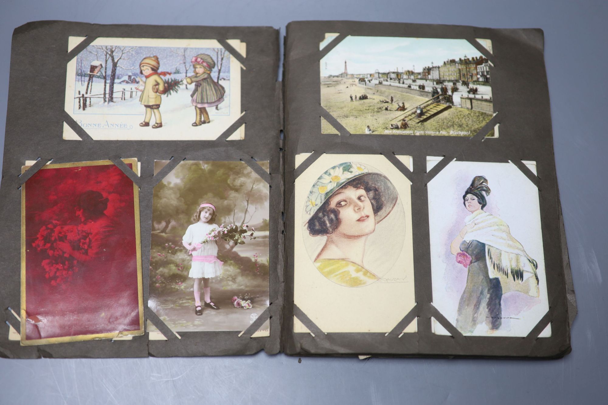 A collection of early 20th century French and English postcards, in an incomplete album